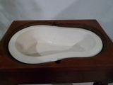 une petite table en bois sur laquelle est posée une baignoire blanche