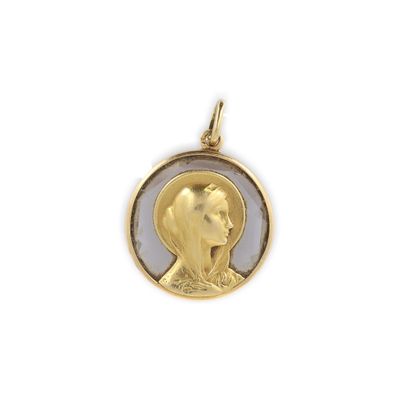 un gros plan sur un pendentif en or représentant le visage d'une femme