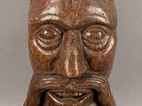 une image représentant une statue en bois d'un homme portant une couronne sur la tête