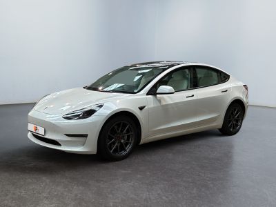 a white tesla model 3 parked in a white room