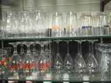 many glasses and bottles on the shelves in the store