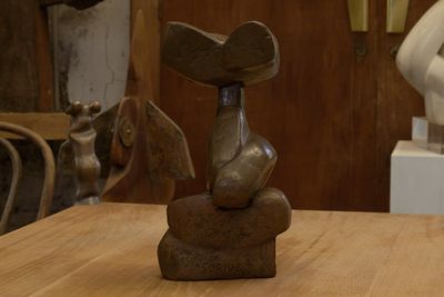 une statue représentant un oiseau perché sur une table en bois