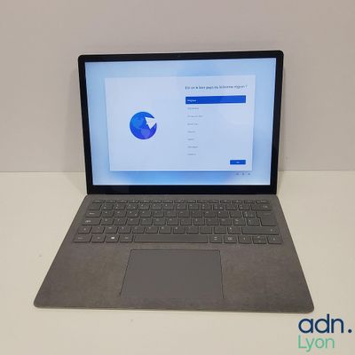 an open laptop computer sitting on top of a white table