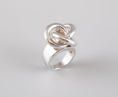 un gros plan d'une bague en argent ornée d'un nœud