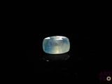 a close up of a ring with a blue stone on a black surface