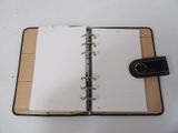 an open notebook with a pen on top of it sitting on a table