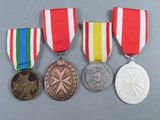 four medals are shown on a gray surface with a red, white, and blue ribbon