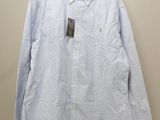 La chemise est suspendue à un cintre accroché au mur.