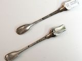 two spoons and a fork sitting on a table
