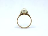 a close up of a ring with a pearl on top of it
