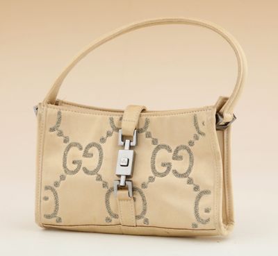 beige guccissi handbag with silver hardware on strap