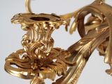 a gold colored chandelier with a bird and flowers on it