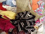a pile of clothes in a suitcase on the floor
