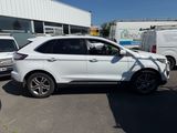 La Ford Edge blanche est garée devant un immeuble.