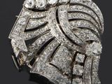 une image représentant une broche en forme de diamant posée sur une surface noire