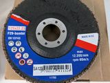 a close up of a metal grinding disc on a cardboard box