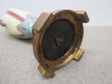 une horloge posée par terre à côté d'un vase