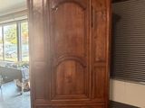une grande armoire en bois au milieu d'une pièce