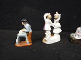 three figurines of people that are standing on a table