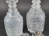 two clear glass vases sitting next to each other on a table