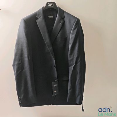 le costume est suspendu à un cintre accroché au mur