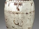 un vase blanc orné de motifs marron sur fond gris