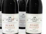 three bottles of red wine are lined up on a white surface