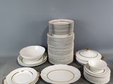 un assortiment de vaisselle blanche et dorée sur une table