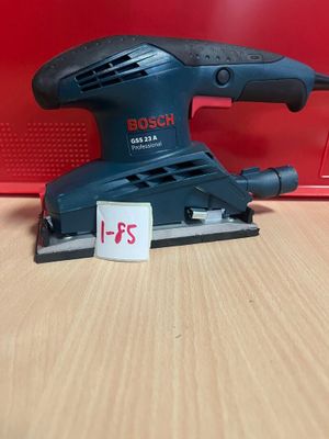 La ponceuse orbitale Bosch se trouve sur une table, à côté d'une boîte rouge