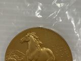 La pièce d'or se trouve dans un sachet en plastique muni d'une étiquette de prix.