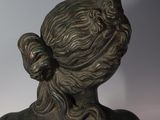 bronze bust of a woman with a bird on her head