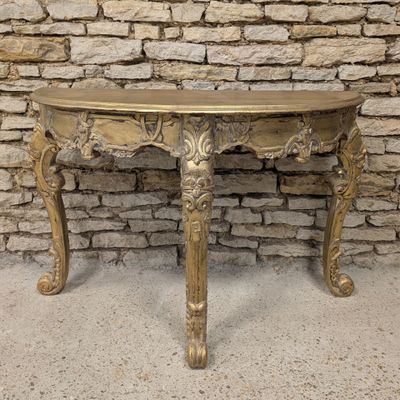 an antique console table with a gold finish and ornate carvings