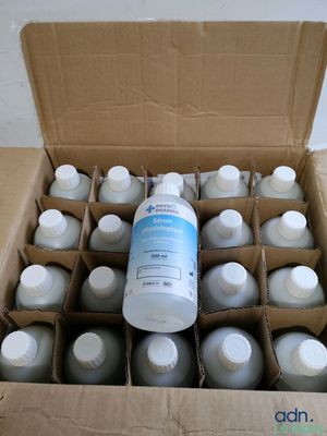 a cardboard box filled with bottles of water and a bottle of liquid