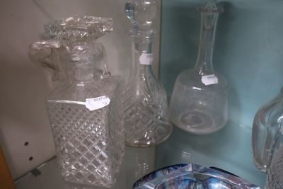 de nombreux vases en verre posés sur une étagère dans une pièce