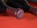 three bottles of wine sitting on a red cloth