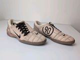 pair of white sneakers with black numbers on them sitting on a white surface