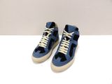 une paire de baskets bleues avec des lacets blancs sur un fond blanc
