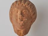 a statue of a head on top of a wooden block
