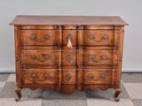 une commode ancienne posée sur un sol en damier