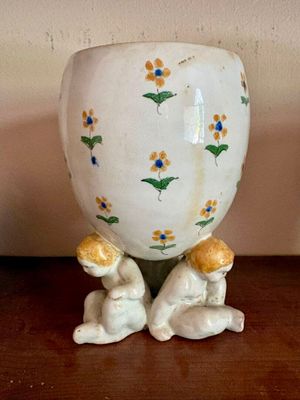 un vase blanc orné de fleurs jaunes et bleues
