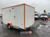 une remorque orange et blanche garée sur un parking à côté d'autres véhicules