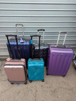 Plusieurs bagages sont alignés contre la porte du garage.