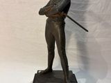 bronze statue of a man with a sword on a marble base