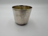 a silver cup on a white table with a white background