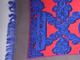 purple and red scarf with blue fringes on a white table