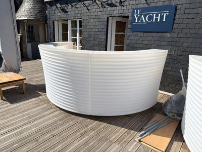 a white boat sitting on a wooden deck next to a building