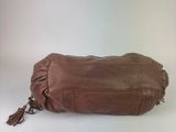 the large brown bag is sitting on a white surface