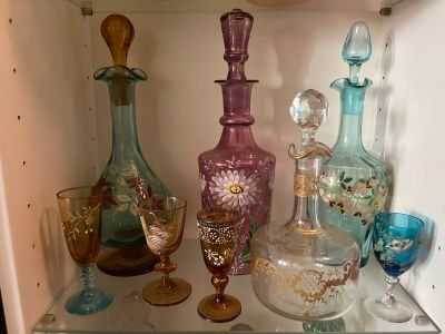 many different colored glass vases on a glass shelf