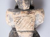 an image of a stone sculpture of a man sitting on top of a pile of rocks