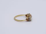 a close up of a gold and diamond ring on a white surface